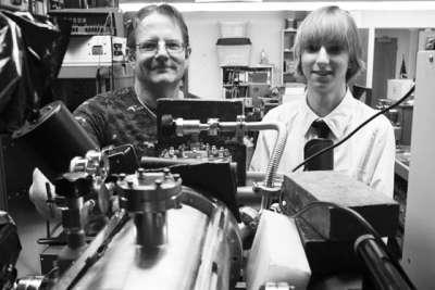 泰勒和他的导师之一比尔在内华达州大学的地下实验室里，前面是泰勒14岁时建立的核聚变反应堆。